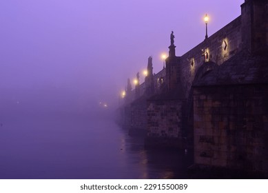Charles Bridge on Vltava River in Prague Old Town. Early morning. Heavy fog.
