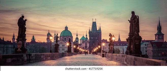 Charles Bridge At Sunrise, Prague, Czech Republic. Dramatic Statues And Medieval Towers. Unique Panoramic View At Dawn When There Are Almost No People On The Bridge.