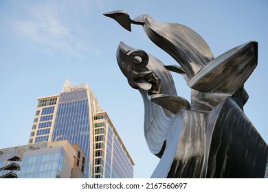 Charlotte, NC - April 2022: A Shot Of The Spiral Odyssey Sculpture With The Kimpton Tyron Park Hotel In The Background