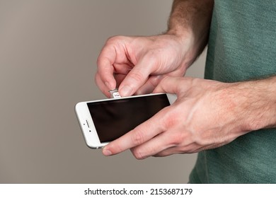 Charlotte, NC - May 3, 2022: Adult Male Swaps Out A Verizon Sim Card From An IPhone With Copy Space And A Shallow Depth Of Field