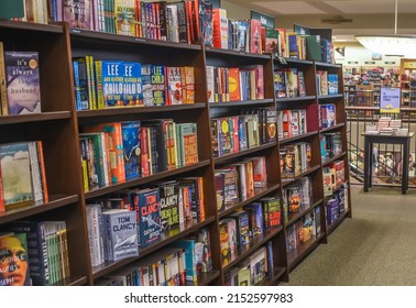 Charlotte, NC USA - July 7, 2019:  Horizontal, medium closeup of interior of bookstore, showing aisle of books on wooden shelves.