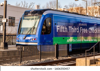 Charlotte, NC/USA - December 26, 2019: Medium Horizontal Shot Of Lynx Blue Line Commuter Train In South Charlotte With Ad For Fifth Third Bank On Side Of Train. Train Is Deep Blue And Stationary.