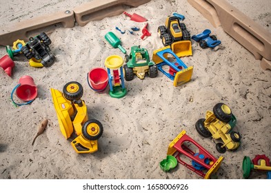 Charlotte, NC/USA - May 26, 2019:  Overhead Shot Of Childrens Sandbox With A Scattering Of Colorful Toys On Beige Or Tan Colored Sand.  No People. Fills Horizontally Oriented Frame..