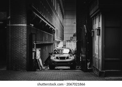 Charlotte, North Carolina, USA - October 27, 2021: Modern SUV Parked In City Alley In Black And White With Film Grain And Dark Shadows