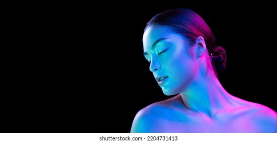 Charm  flirt  Young beautiful girl and well  kept skin   without makeup isolated over dark background in neon light  Concept natural beauty  art  emotions  cosmetics   youth  Flyer for ad