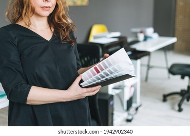 Charming Adult Woman Middle Aged With Curly Hair Architect Designer With Color Palette In Hands In Modern Office Working Moment