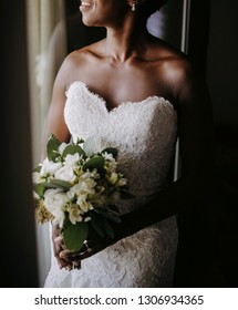 Charming African American bride smiles standing before the window