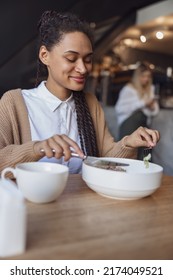 Charming African Young Woman In Casual Clothes Enjoying Her Lunch During Lunch Break At Food And Drink Establishment