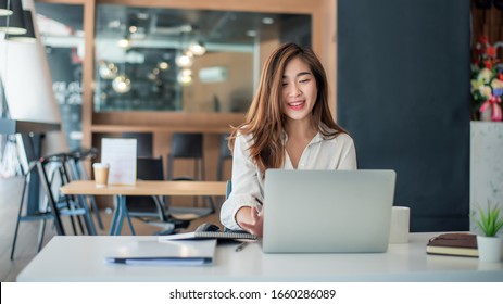 Charming asian businesswoman sitting working on laptop in office. - Shutterstock ID 1660286089