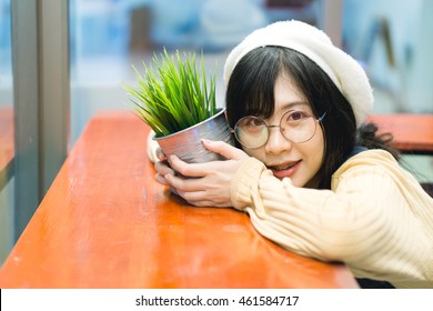 Charming Asian Girl Holding Pot With A Plant.