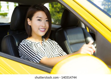 A Charming Asian Lady Driving A Yellow Car.