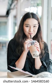 Charming Asian Woman Sitting Drinking Pearl Milk Tea Happily.