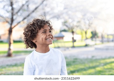 Charming Beautiful Black young boy with a playful smile and curly hair. Outdoor candid portrait of a natural beauty - Shutterstock ID 2311622699