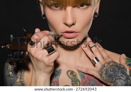 charming blonde with tattoo machine and for them, dark background