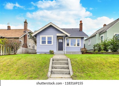 Charming Blue Home Exterior With Green Grass In The Front Yard.