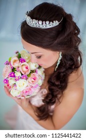 Charming Bride With Tiara Holding Bouquet In Her Hands, Top View