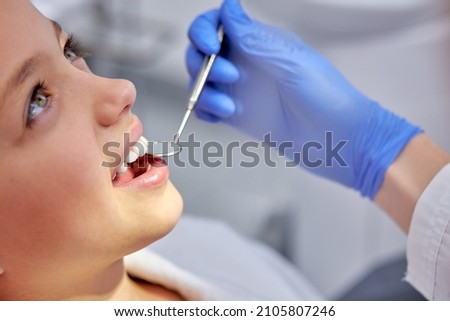 Charming caucasian child girl is examined by dentist in dental clinic. Healthy teeth and medicine concept.Close-up photo of child's face, sits on couch during checkup, before treatment Сток-фото © 