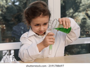 Charming Caucasian little girl, preschooler child in white lab coat, pouring a solution into a test tube and watching the chemical reaction with fascination and excitement during a chemistry lesson - Shutterstock ID 2191788697