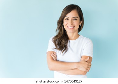 Charming Caucasian Woman With Arms Crossed Smiling Against Colored Background