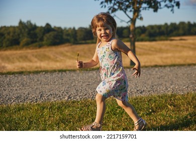 Charming Child In A Sundress Running Down The Street In The Suburbs