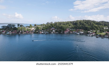 Charming coastal village nestled by the water, with colorful houses, boats, and lush greenery under a clear blue sky - Powered by Shutterstock