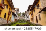 Charming colonial street with colorful buildings in Cajamarca, Peru, leading to a distant church.