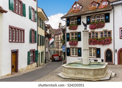 Charming colourful typical town square in Basel, Switzerland with a Gemsberg goat fountain and houses with flowers, typical Swiss scenery and cityscape. 