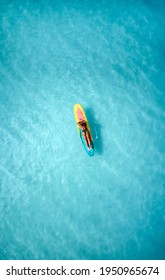 Charming curly African-American dark-skinned young woman, professional surfer relax on a long surfboard in the ocean, aerial shot from above  - Shutterstock ID 1950965674