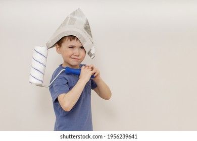 Charming Cute Little Emotional 5-year-old Boy In A Newspaper Hat Holds A White Roller In His Hands. сoncept Of Apartment House (renovation )