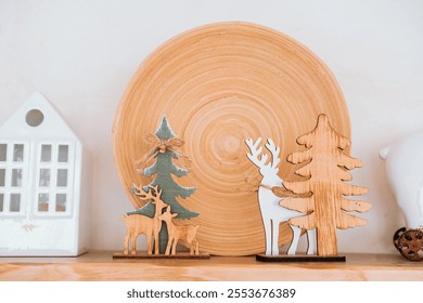 A charming display features wooden reindeer and trees set against a large rustic plate. The scene captures a cozy, festive atmosphere perfect for holiday decorating. - Powered by Shutterstock