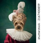 Charming doggy looking at camera. Woman like medieval person in vintage outfit headed by dog