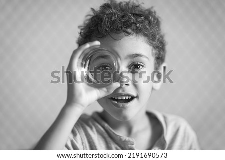 Similar – Happy kid looking at camera through magnifying glass