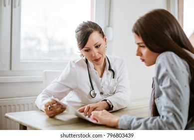 Charming female doctor giving advice to a female patient. 