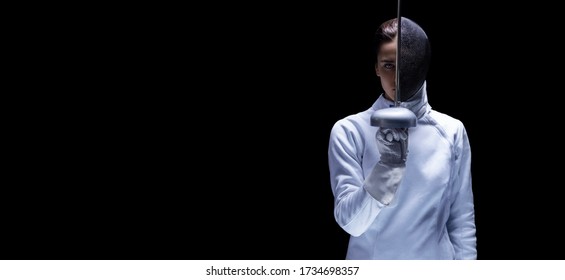 Charming girl in a fencer costume posing on a black background. The sword separates the head into a face and a mask. The concept of fencing. Mixed media - Powered by Shutterstock