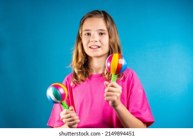 Charming girl in pink incendiary dances with maracas. The concept of music and dance, entertainment among young people, traditions in art, creativity and self-development. - Powered by Shutterstock