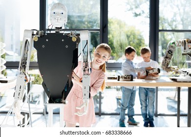 Charming Girl Posing Behind A Human Robot Back