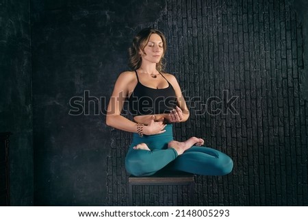 a charming girl in a sports uniform does yoga in an old room with a fireplace and candles