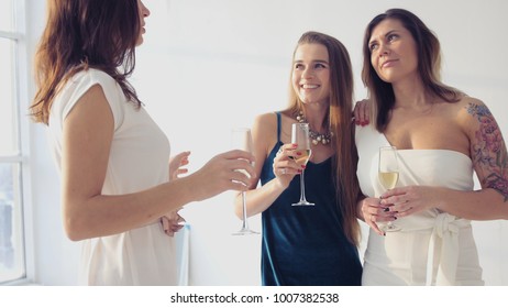 Charming girls congratulate the girlfriend, hug her, holding glasses in her hands. HD