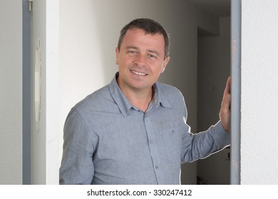 Charming and handsome man opening the door isolated