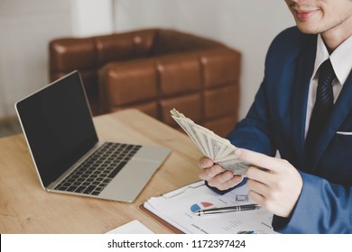 Charming Handsome Young Guy Is Counting Money. Attractive Handsome Businessman Can Earn A Lot Of Money. Glamour Man Can Find Several Way For Earning Money From Internet Online By Only Using Laptop