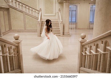 Charming happy bride with long veil. Marble staircase