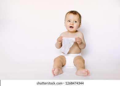 Charming Happy Little Baby Girl In White Diaper Holding Wet Wipe In Her Hands And Sitting Isolated On White Background. Cleaning Wipe, Pure, Clean