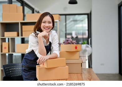 Charming And Happy Young Asian Female Startup Entrepreneur In Her Office Stock Room, Smiling And Looking At Camera.