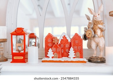 A charming holiday arrangement features colorful gingerbread houses amid lanterns and a rabbit statue. The warm decor captures the festive spirit in a cozy setting, perfect for winter celebrations. - Powered by Shutterstock