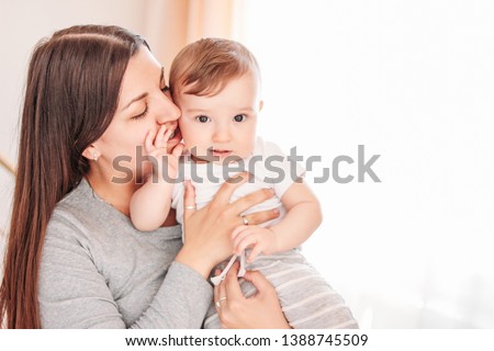 Charming little baby boy 6-8 months with mother at home, close up candid portrait