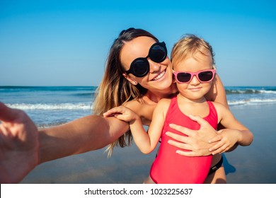 Charming Little Girl And Her Mom Are Photographed On The Phone