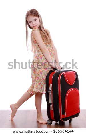 Charming little girl in summer dress with suitcase