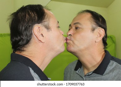 Charming Man In His 50 Years Old Kissing A Mirror, Having His Image Reflected In It, Kissing Himself