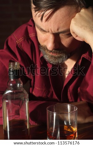 Charming man sits quietly at his home at the table