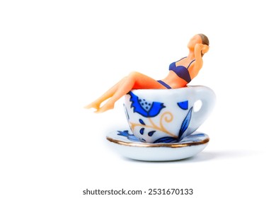 Charming miniature female figure in swimming suit lounging in decorative teacup, symbolizing relaxation and leisure concept. - Powered by Shutterstock